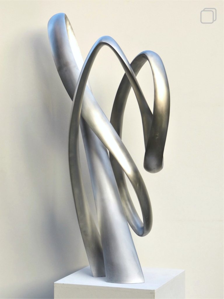 Abstract aluminum sculpture. A slim band going up and down.