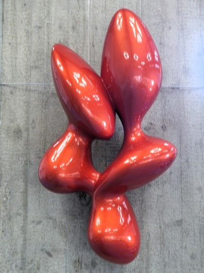 Abstrakt Skulptur bestehend aus 5 organischen Formen, die um eine leere Mitte arrangiert sind, Oberfläche glänzend rot lackiert.