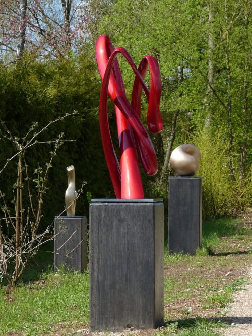 Auf der Landesgartenschau Ellwangen: Skulptur aus auf und abstrebenden glatt polierten Schlaufen, glänzend rot lackiert